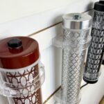 Close-up of decorative short tubular lights with patterned metal mesh and colored end caps