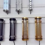 Short IK10-rated decorative tubular lights with metal mesh, honeycomb, and patterned cores – gold, black, pink, and silver architectural tube fixtures for interior lighting