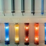 Decorative short LED tube lights with patterned metal mesh and colored end caps – E27-style tubular fixtures in warm and cool lighting for interior architectural applications