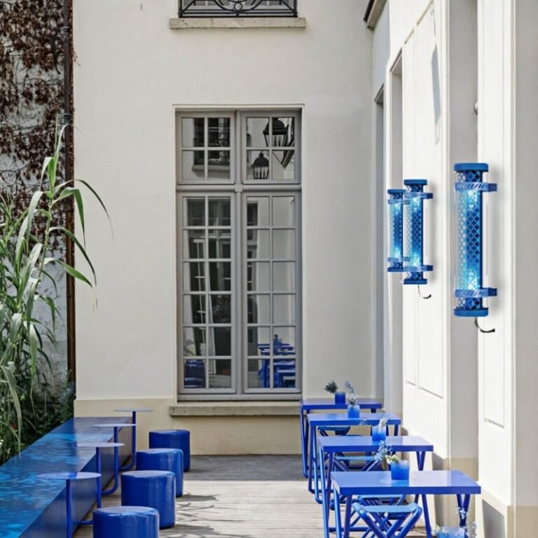Moreau decorative tubular wall lights installed outdoors, featuring blue metal grille and E27 lamp system in a hospitality courtyard setting