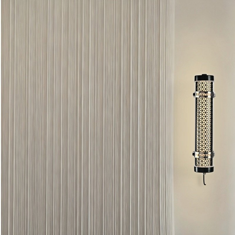 Architectural tubular wall luminaire with metal grille integrated into minimal interior space